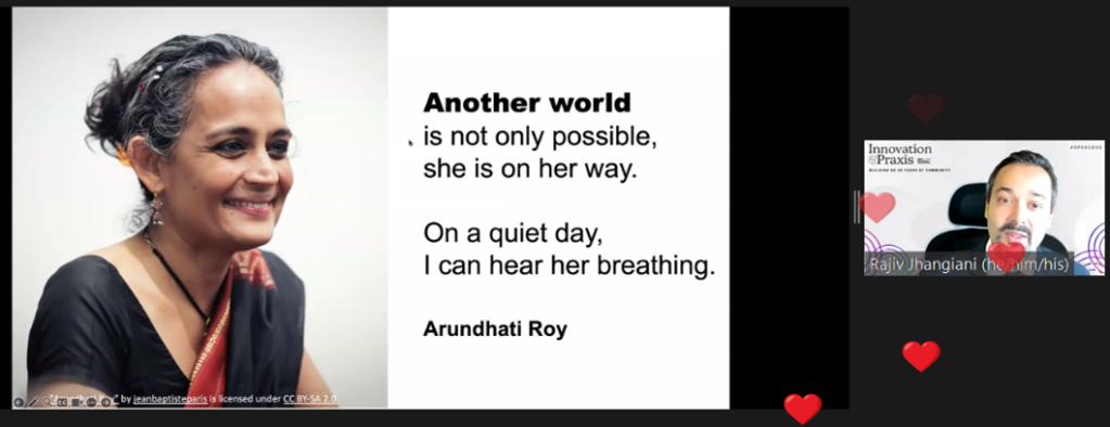 Screenshot of Zoom presentation with heart emojis flooding the presenter, and Arundhati Roy quote on slide: "Another world is not only possible, she is on her way. On a quiet day, I can hear her breathing."